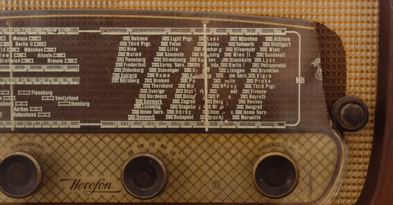 Close-up of a vintage radio displaying station names and frequency dial for a nostalgic effect.