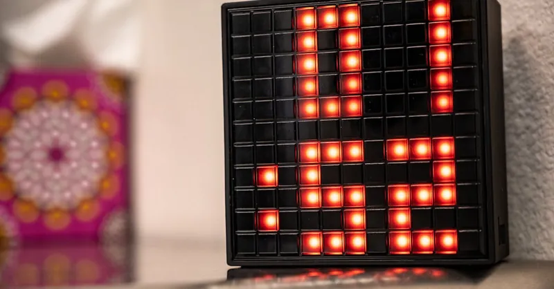 Close-up of a digital clock showing 01:52 with red LED lights, creating a modern and illuminated look indoors.