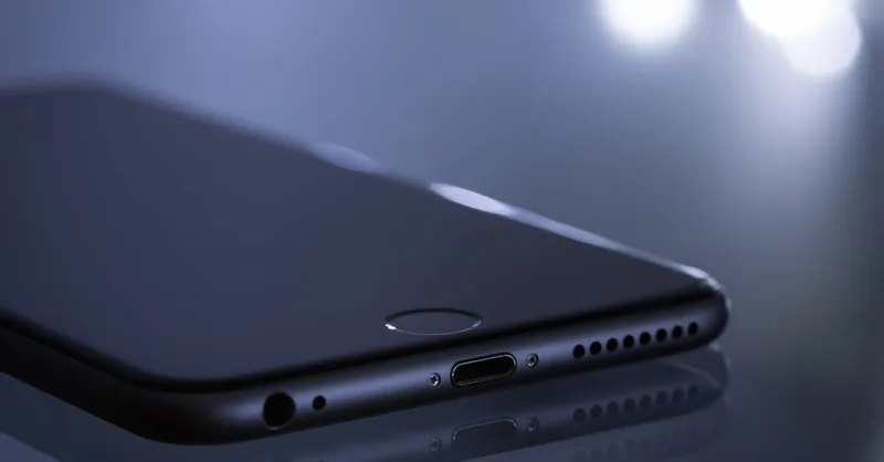 Close-up of a sleek smartphone with a blurred bokeh reflection, showcasing modern technology design.
