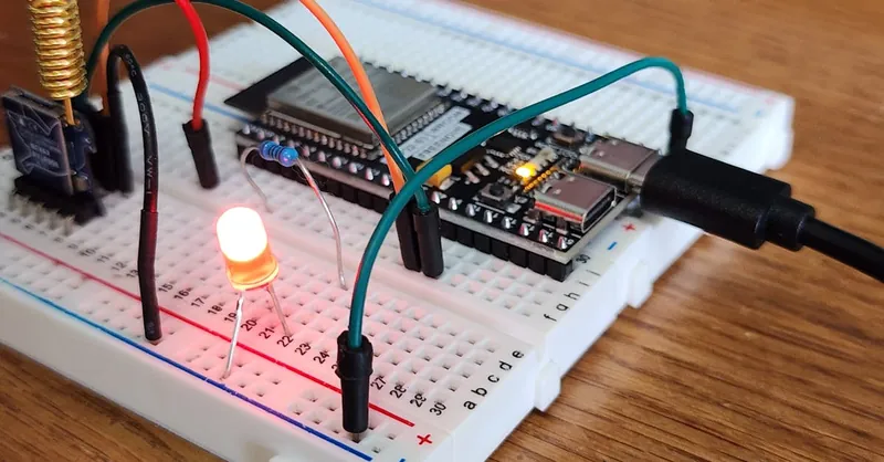 Detailed view of a breadboard with LED and microcontroller, showcasing DIY electronics.