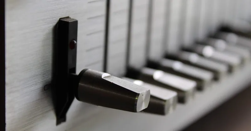 Detailed view of a vintage audio control panel switch and sliders in focus.