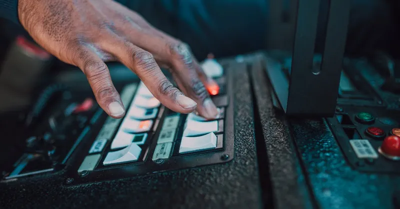 A close-up view of a hand manipulating switches on a control panel, showcasing technology interaction.