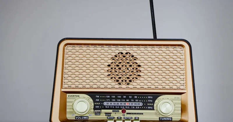 Classic retro design radio featuring an antenna and golden front speaker grill.